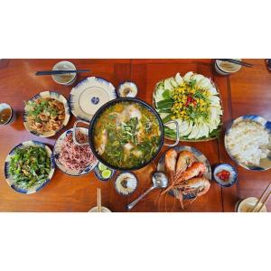 a table with many different dishes of food on it at Comfy room - InnerZen Mekong Riverside homestay Ben Tre in Ben Tre