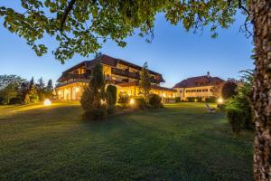 a large building with lights on a grass field at Hotel Marko in Sankt Kanzian
