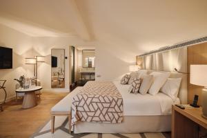 a bedroom with a large white bed and a desk at Hospes Palau de La Mar, Valencia, a Member of Design Hotels in Valencia