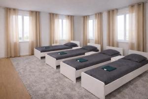 three beds in a room with windows at Comfort Stay Koblenz in Koblenz