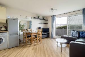 a kitchen and living room with a table and a couch at Bay Retreat- Moments from Hamworthy Park in Poole