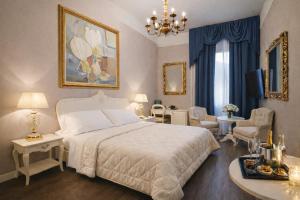 a bedroom with a white bed and a living room at Hotel Ristorante Ala d'Oro in Lugo
