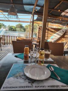 a table with a plate and glasses on a table at Cap du Roc in Port-la-Nouvelle
