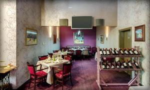 ein Esszimmer mit Tischen und Stühlen und einem Fernseher in der Unterkunft Alliance Hotel in Plowdiw