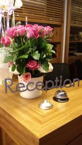 a vase of pink roses sitting on top of a table at Caramel Boutique Hotel in Beirut