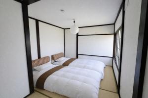 a bedroom with two beds and a large window at 椴松 l フルリフォーム l 貸切の一軒家 l 千歳空港まで30分 l Todomatsu in Yuni
