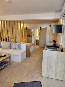 a living room with a couch and a kitchen at Jemphasis-New Apartments Mykonos in Agios Ioannis Mykonos