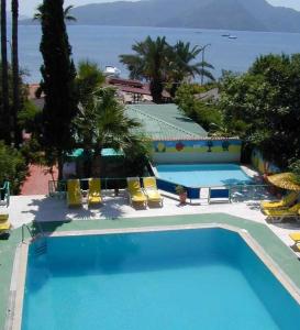 una gran piscina con sillas y el océano en Amos Hotel, en Marmaris