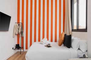 a bedroom with a white bed with an orange striped wall at Corner Residence by GoodMove - Casablanca in Casablanca