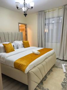 a bedroom with a large white bed with yellow pillows at pk Luxury Homes in Nairobi