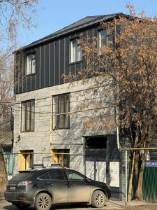 a black car parked in front of a building at GuestHouse-Medeu in Almaty