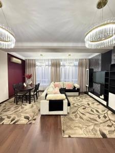 a living room with a couch and a table at Ala-Too Central Square Residence in Bishkek