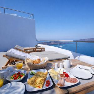 a table with food on it with a view of the ocean at Ikastikies Suites in Firostefani