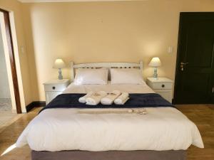a bedroom with a bed with two towels on it at Iconic Villa in Arniston in Arniston