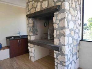 a stone fireplace in a room with a kitchen at Iconic Villa in Arniston in Arniston +44 photos