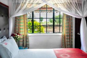a bedroom with a bed and a large window at Muthu Mara River Lodge in Masai Mara +84 photos