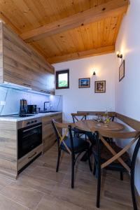 a kitchen and dining room with a table and chairs at Vikendice Kutlešić in Čajetina