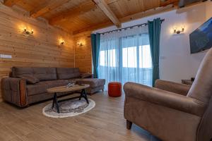 a living room with a couch and a table at Vikendice Kutlešić in Čajetina