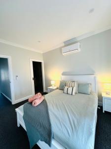 a bedroom with a large bed with pillows on it at Escape on Eighth Poolside Comfort Close to CBD in Mildura +56 photos
