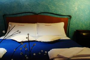 a bed with a blue comforter and pillows on it at La Casa sulla Collina d'Oro in Piazza Armerina