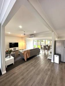a large living room with a couch and a tv at Escape on Eighth Poolside Comfort Close to CBD in Mildura