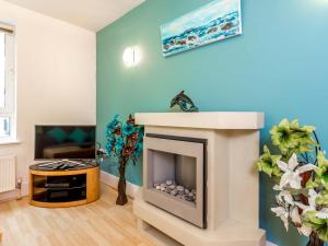 a living room with a fireplace and a tv at Baywatch - Private Balcony Overlooking Poole Quay in Poole