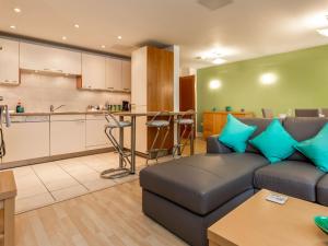 a living room with a couch and a kitchen at Baywatch - Private Balcony Overlooking Poole Quay in Poole