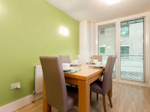 a dining room with a wooden table and chairs at Baywatch - Private Balcony Overlooking Poole Quay in Poole