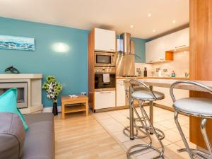 a kitchen with a couch and chairs in a room at Baywatch - Private Balcony Overlooking Poole Quay in Poole +19 photos