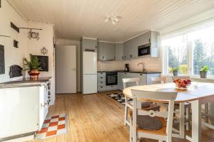 a kitchen with white cabinets and a table and chairs at KRO803-Haeradsbaeck-Ellagoelshult-4 in Häradsbäck