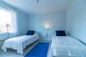 a blue room with two beds and a window at KRO803-Haeradsbaeck-Ellagoelshult-4 in Häradsbäck