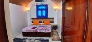 a bedroom with a bed and a blue window at Masa Nubian House in Aswan