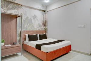 a bedroom with a large bed with a wooden headboard at Super HOTEL O KASHIKKAA PREMIUM in Bhubaneshwar +31 photos