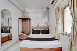 a bedroom with two beds and a window at Super HOTEL O KASHIKKAA PREMIUM in Bhubaneshwar