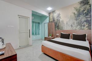 a bedroom with a large bed and a painting on the wall at Super HOTEL O KASHIKKAA PREMIUM in Bhubaneshwar
