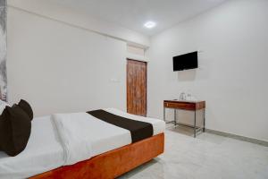 a bedroom with a bed and a television in it at Super HOTEL O KASHIKKAA PREMIUM in Bhubaneshwar