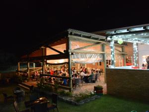 Hokahanya Inn & Conference Centre في ماسيرو: مجموعة من الناس يجلسون في مطعم في الليل