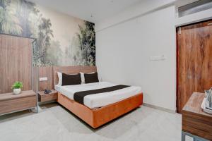 a bedroom with a bed and a painting on the wall at Super HOTEL O KASHIKKAA PREMIUM in Bhubaneshwar