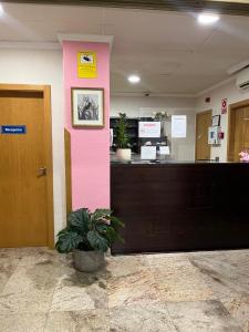 a pink pillar in an office with a desk at Hostal Jijones in Villarrubia de los Ojos