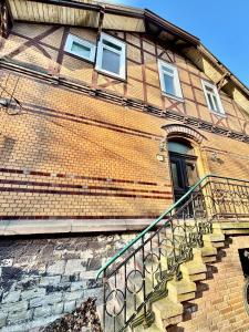 a brick building with a staircase in front of a door at Villa Sartorius - charmant und denkmalgeschützt wohnen nahe Göttingen in Bovenden