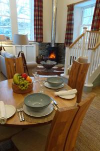 a dining room table with plates and fruit on it at School Room in Lochgilphead