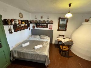 a small room with a bed and a table at Kotlós Tanya in Zákányszék