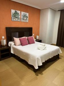 a bedroom with a large bed with pink pillows at Hostal Jijones in Villarrubia de los Ojos