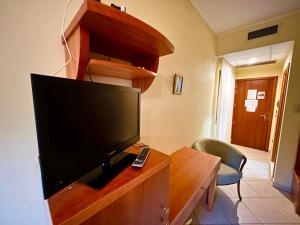 a living room with a television on a wooden entertainment center at Residence Perla - Costa in Salve