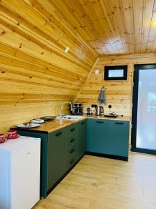 a kitchen with green cabinets and a wooden ceiling at Cottage Dachi in Mestia in Mestia