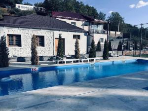 a large swimming pool in front of a house at Malishka Eco Villas