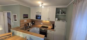 a kitchen with white cabinets and a counter top at Perlmuschel in Borkum