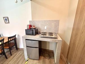 a kitchen with a counter with a stove and a microwave at Habitacion olas altas in Mazatlán