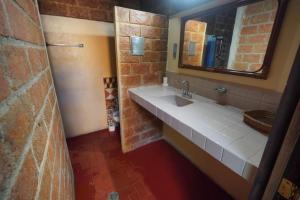 a bathroom with a sink and a brick wall at Habitacion Faro in Mazatlán
