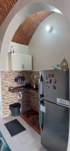a kitchen with a refrigerator and a brick wall at Masa Nubian House in Aswan +69 photos
